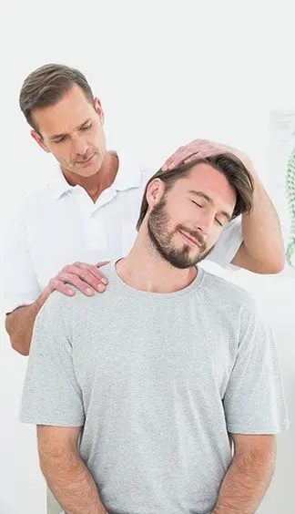 Chiropractor performing a gentle neck adjustment on a seated patient