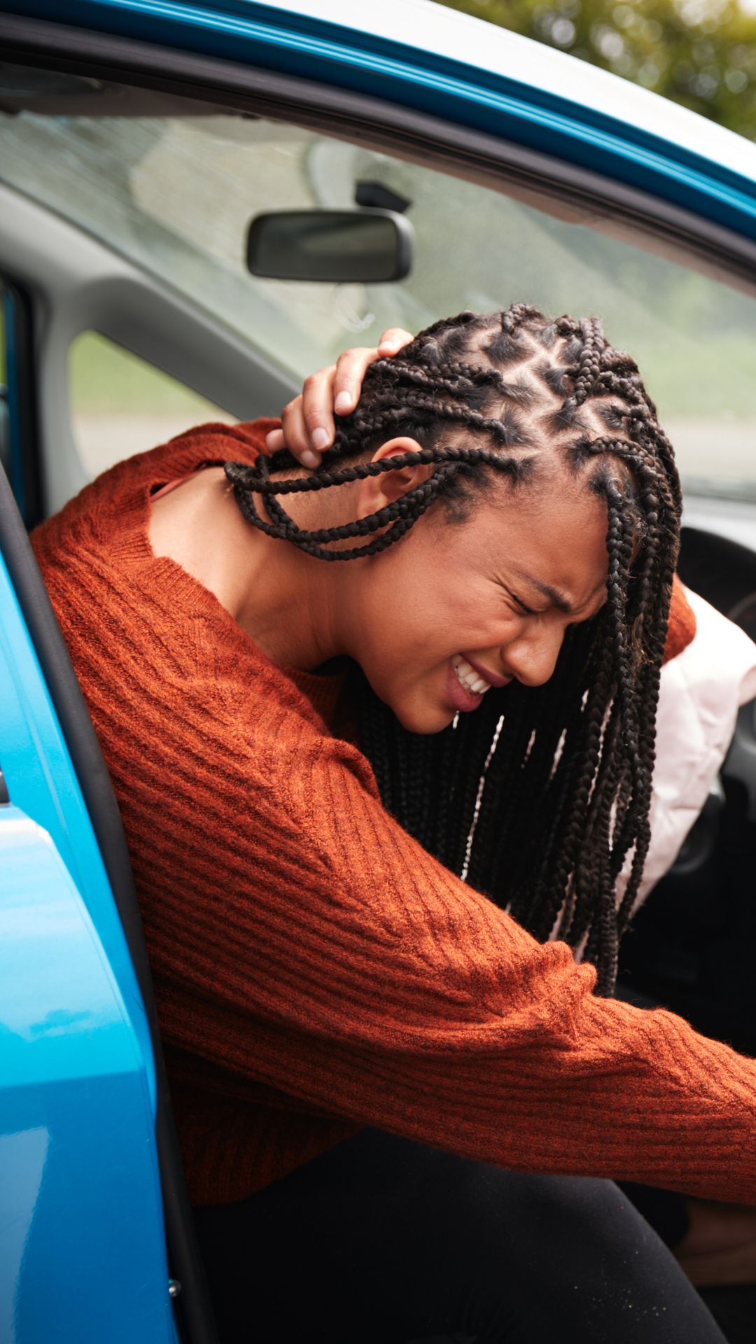Driver holding her neck after a car accident
