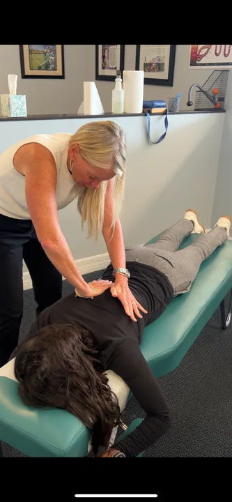 Dr. Kim Raby adjusting a patient's mid-back
