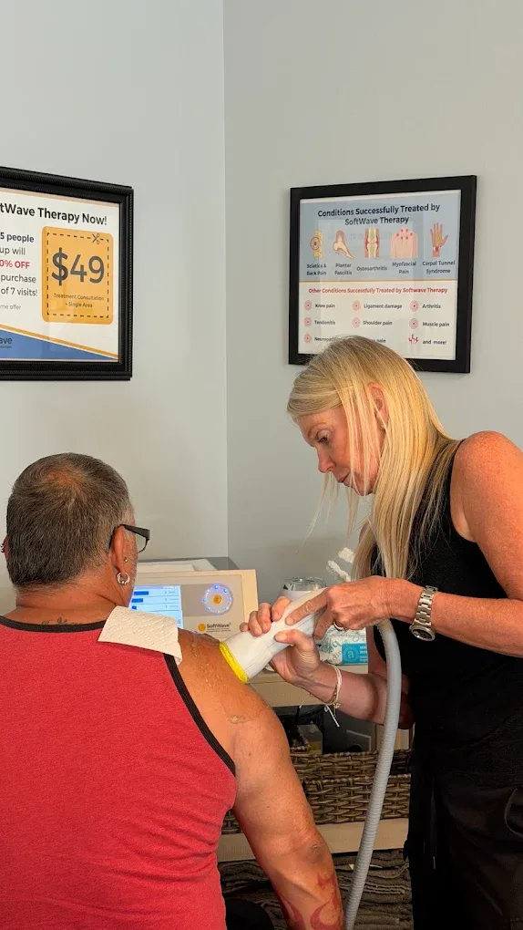Dr. Raby applying SoftWave therapy to a patient's shoulder