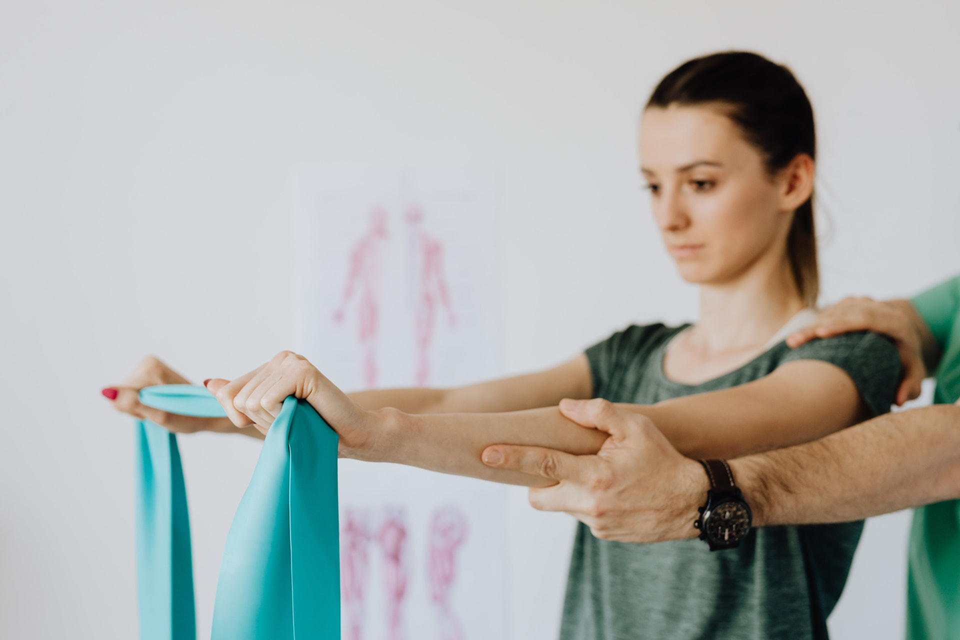 Chiropractor guiding a patient through a resistance band strengthening exercise